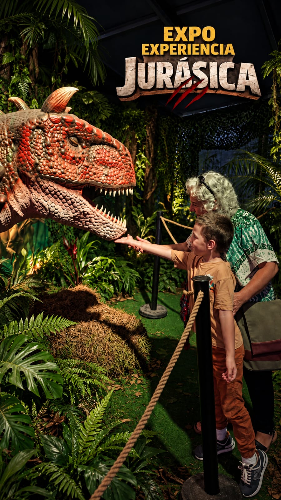Uma criança e uma mulher observam de perto um dinossauro da exposição